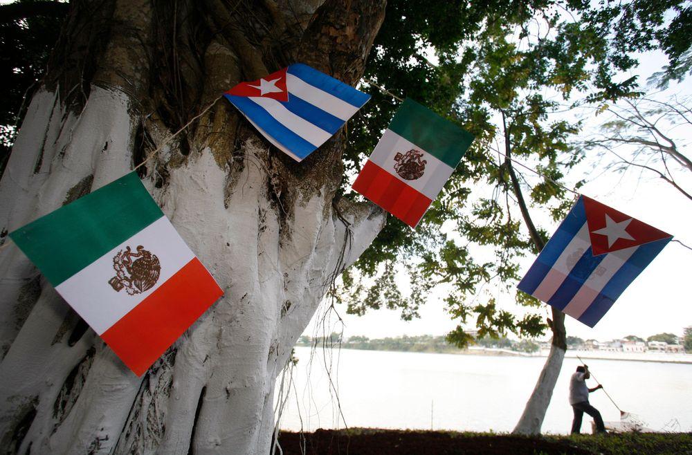 Banderas cubanas y mexicanas colgadas de un árbol (Tomás Bravo/REUTERS)