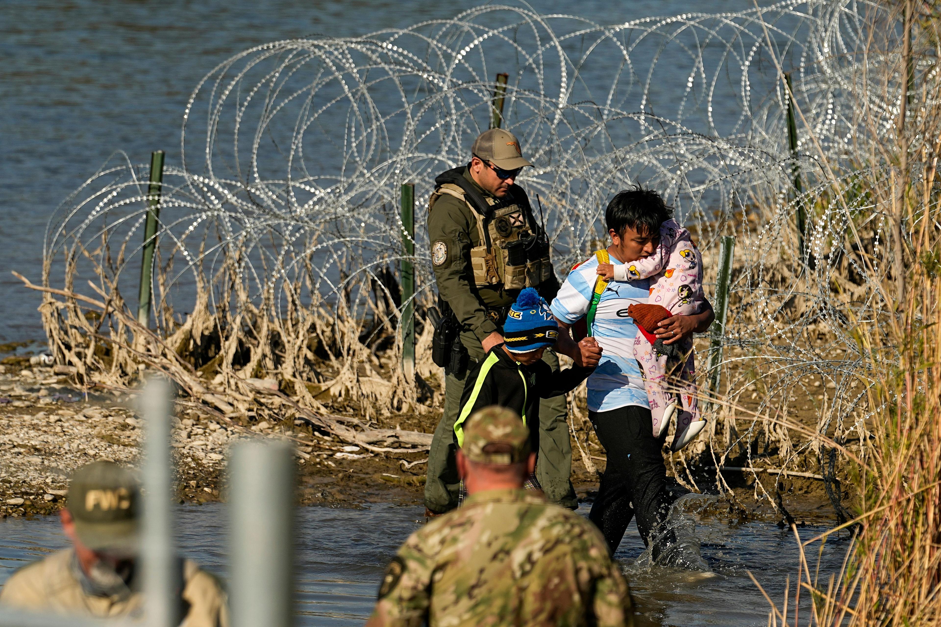 Migrantes son detenidos por funcionarios en la frontera entre Texas y México, el 3 de enero de 2024. (Foto: AP/Eric Gay/Archivo)