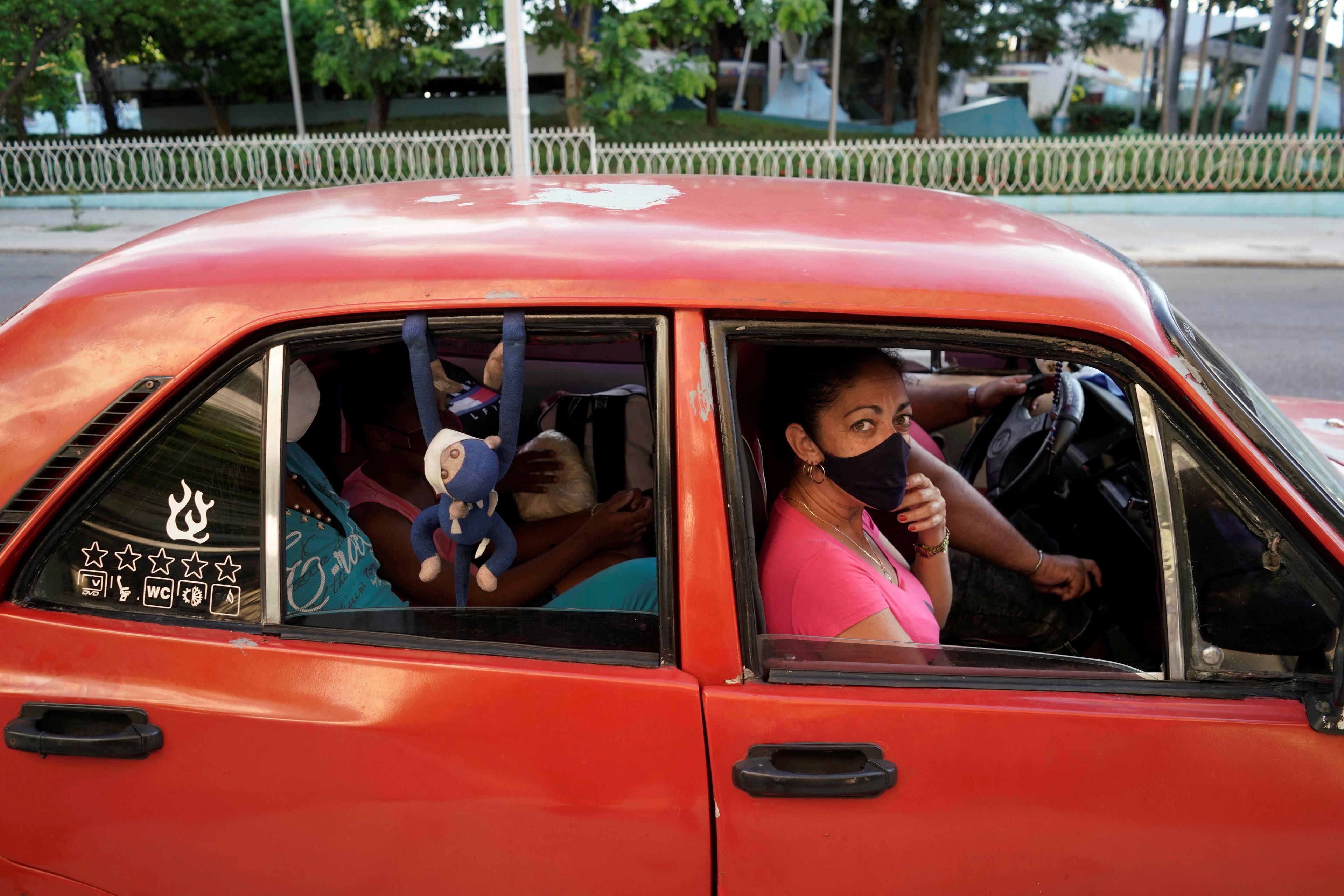 Cubanos viajan en auto usando mascarilla facial (REUTERS/Alexandre Meneghini)