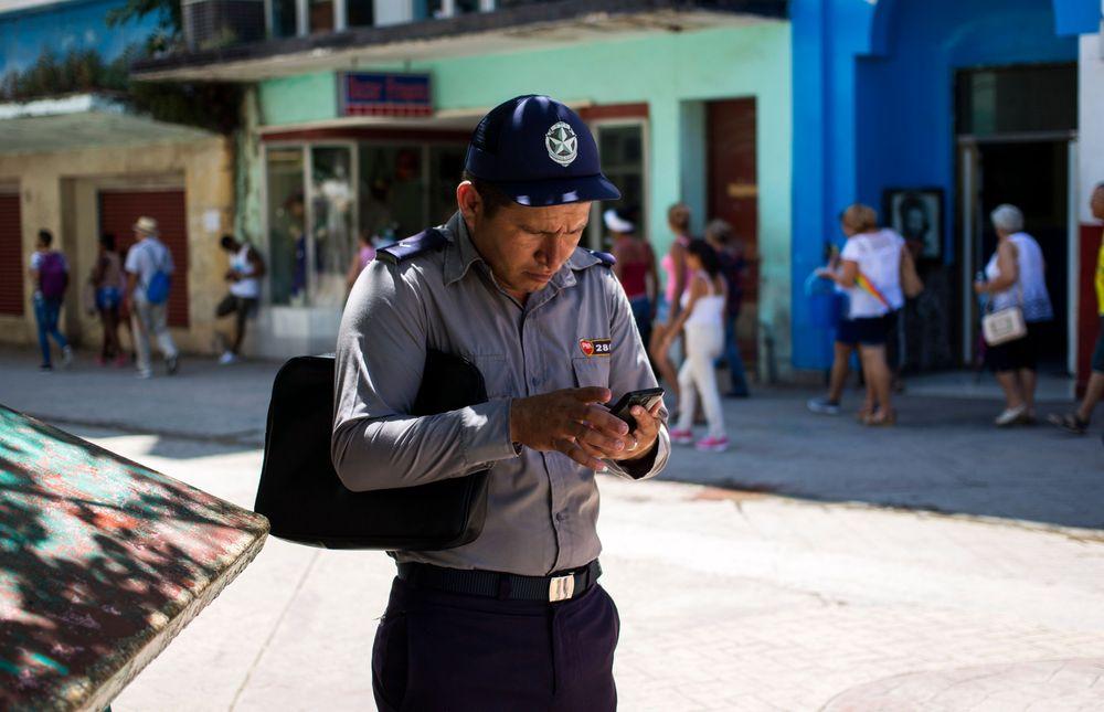 Un policía se conecta a Internet usando un teléfono celular en La Habana (Archivo)-AP/Desmond Boylan)