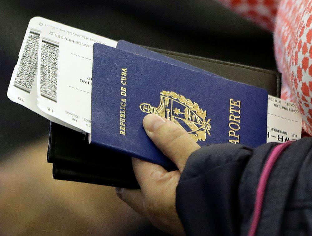 Una persona sostiene su pasaporte cubano antes de subir a un vuelo (Julio Cortez/AP)