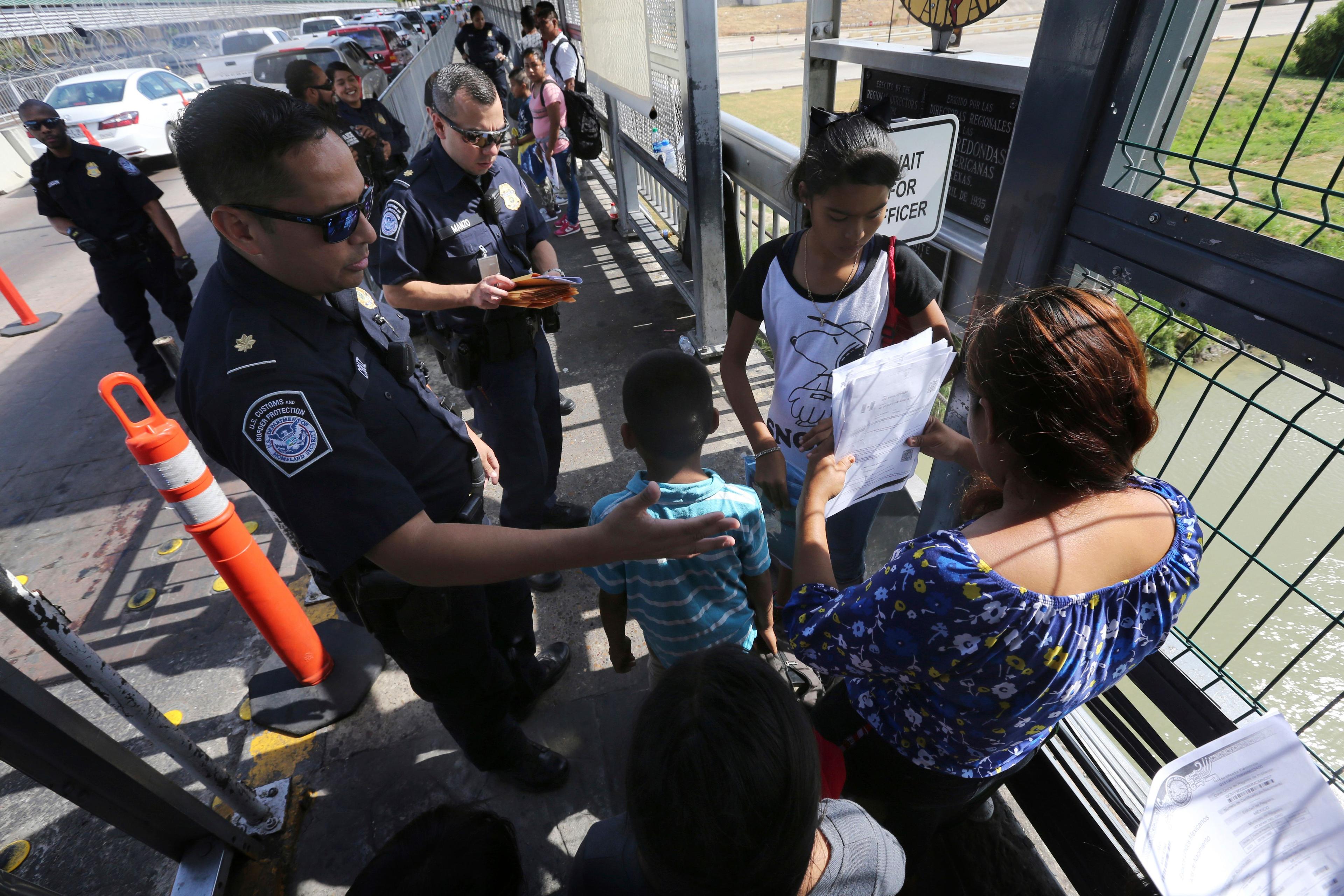 Oficiales de Aduanas y Protección Fronteriza de EE. UU. revisan los documentos de migrantes en el Puente Internacional 1 en Nuevo Laredo, México. (AP/Marco Ugarte/Archivo)  